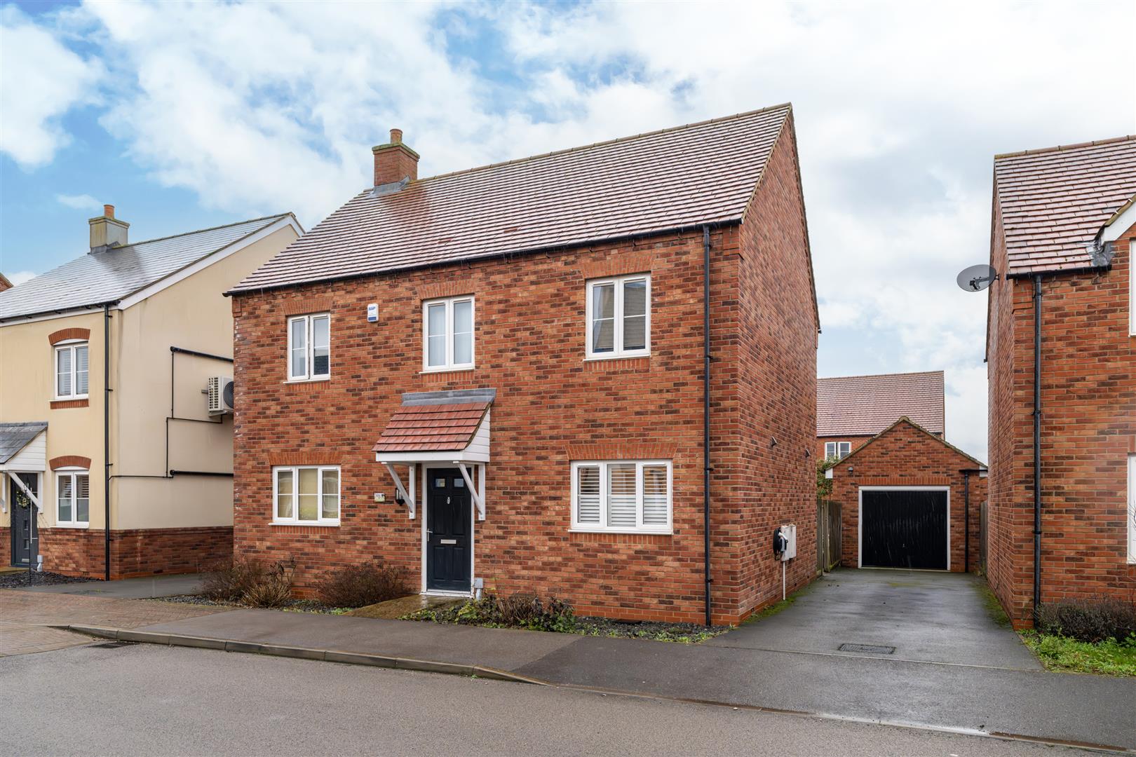 Red brick house with driveway and garage.